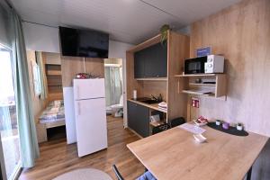 a small kitchen with a table and a white refrigerator at L&A Mobile House in Metlika +31 photos