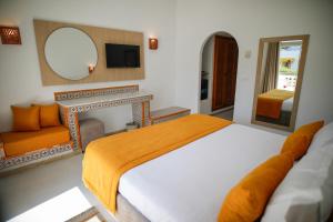 a bedroom with a bed and a mirror and a chair at Hôtel Hammamet Beach in Hammamet
