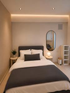 a bedroom with a large bed and a mirror at Dizengoff Square Garden - by BAR COLLECTION in Tel Aviv