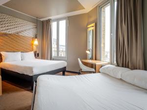 a hotel room with two beds and a window at ibis Bordeaux Centre Gare Saint Jean Euratlantique in Bordeaux +55 photos