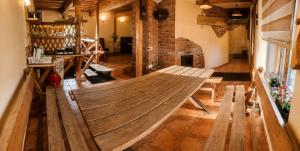 a large wooden bench in a room with a fireplace at Neimaņu sēta Apartments in Augšlīgatne +3 photos