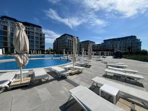 a swimming pool with lounge chairs and umbrellas at Sea Breeze Polo in Nardaran
