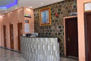 un hall avec un mur en pierre et un comptoir de réception dans l'établissement Green Mountain Hotel Apartments, à Al ‘Aqar