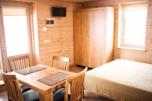 a dining room with a table and two beds at Aitvaras in Anykščiai