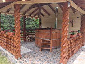 a wooden gazebo with a hot tub at Cabana Luciana in Dămuc +29 photos