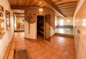a large room with a brick wall and wooden ceilings at Neimaņu sēta Apartments in Augšlīgatne