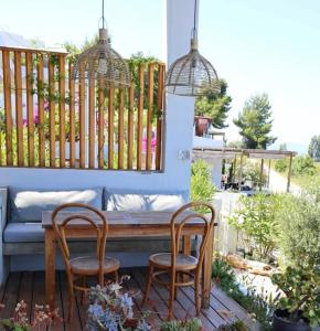 a patio with a wooden table and two chairs at Villa Tulivu in Paleros +16 photos