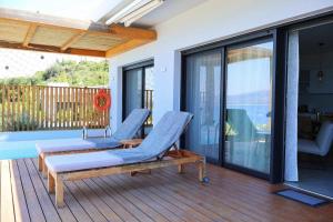 a patio with two chairs and a table on a deck at Villa Tulivu in Paleros