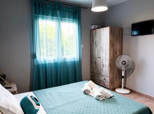 a bedroom with a bed with green curtains and a window at Aegli House in Theológos