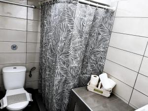 a bathroom with a black and white shower curtain at Aegli House in Theológos +10 photos