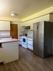 a kitchen with white cabinets and a stainless steel refrigerator at 6 bedroom house in Victoria
