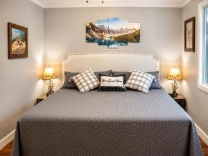 a bedroom with a large bed with two lamps at Peaceful Pine Place Cabin in Pine
