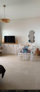 a white dining room with a table and chairs at Jason Rooms & Studios in Keratokampos