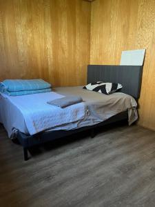 a bed in a room with a wooden wall at 6 bedroom house in Victoria +15 photos