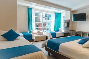 a hotel room with three beds and a tv at Xperience Hotel in Baños +98 photos