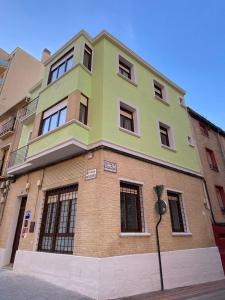 a green and brown building on the side of a street at Grampy Boutique Hostal - Zaragoza Centro in Zaragoza