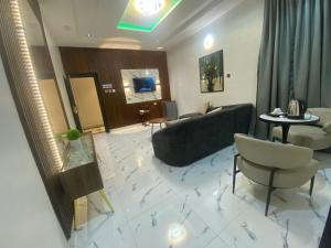 a living room with a couch and a table and chairs at Spenza Hotel and Suites in Asaba