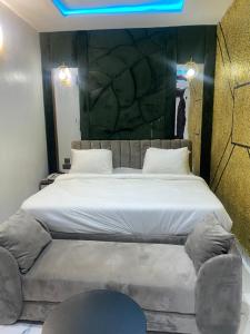 a bedroom with a large bed with a tufted headboard at Spenza Hotel and Suites in Asaba