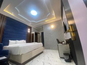 a bedroom with a large bed and a blue wall at Spenza Hotel and Suites in Asaba