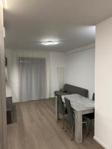 a dining room with a table and chairs in a room at Grey loft in Torvaianica