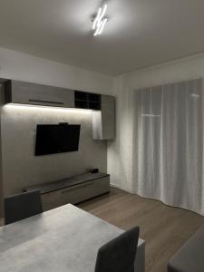 a living room with a table and a television at Grey loft in Torvaianica