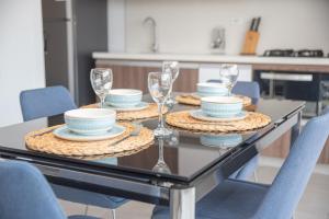 a dining room table with plates and glasses on it at Ginebra central laureles estadio in Medellín