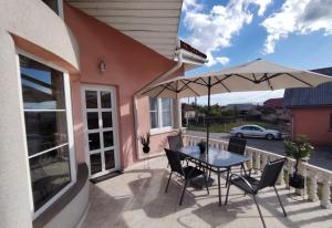 a patio with a table and an umbrella at The HOME in Ditrău