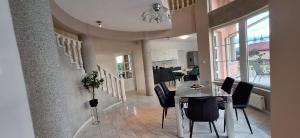 a dining room and kitchen with a table and chairs at The HOME in Ditrău