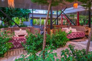 a restaurant with tables and chairs and trees at Adrasan Çıtır Pansiyon in Kumluca
