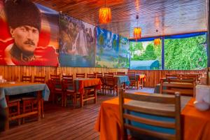 a restaurant with tables and chairs and a large painting on the wall at Adrasan Çıtır Pansiyon in Kumluca +24 photos