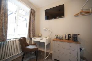 a bedroom with a desk and a chair and a window at Modern Studio - Central Location in Southport