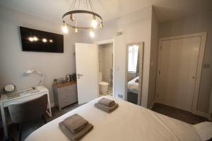 a bedroom with a bed with two towels on it at Modern Studio - Central Location in Southport