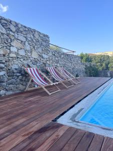two lounge chairs on a wooden deck next to a swimming pool at Casa de Ramalde in Porto