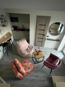 a living room with chairs and a table and a mirror at Apartments ,,Morena'' Melnragė in Melnragė
