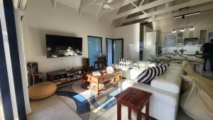 a living room with a white couch and a tv at Apollo on Sea in Velddrif