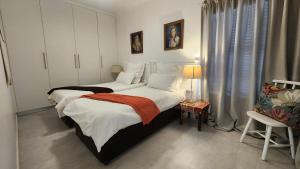 a bedroom with two beds and a chair at Apollo on Sea in Velddrif