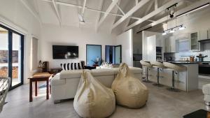 a living room with a white couch and a kitchen at Apollo on Sea in Velddrif