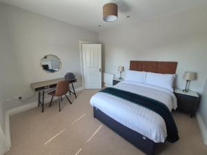 a bedroom with a bed and a desk with a mirror at AbbeyLane house in Trim