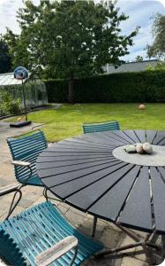 a blue table and chairs with a table and umbrella at Cozy house in Hasseris in Aalborg