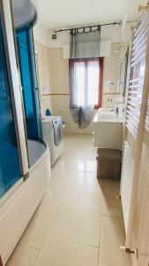 a bathroom with a tub and a toilet and a sink at stanza a casa marina in Rosolina +14 photos