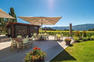 a patio with a table and chairs and an umbrella at Private Boho Tiny Home - Lakes, Wineries, Hike, Ski in Kelowna