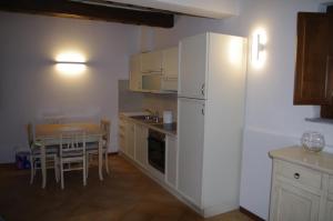 a kitchen with a white refrigerator and a table at Roby's House in Gaiole in Chianti