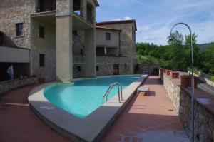 a swimming pool in front of a building at Roby's House in Gaiole in Chianti