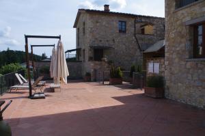 a patio with an umbrella and a building at Roby's House in Gaiole in Chianti