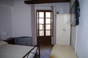a room with a bed and a refrigerator and a door at Roby's House in Gaiole in Chianti