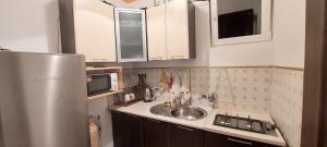 a kitchen with a sink and a stainless steel refrigerator at Вікенд WeekEnd in Kvasy