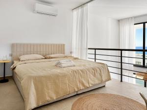 a bedroom with a large bed and a balcony at LUKA Duplex SeaView and Terrace in Aglantzia +1 photo