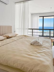 a bedroom with a large bed with a view of the ocean at LUKA Duplex SeaView and Terrace in Aglantzia