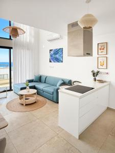 a kitchen and a living room with a blue couch at LUKA Duplex SeaView and Terrace in Aglantzia