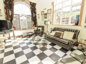 a living room with leather furniture and a checkered floor at White Heather Cottage in Killaloe